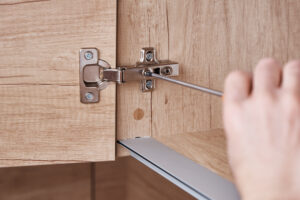 Screwdriver fixing kitchen cabinet door, close up